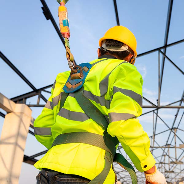 Man secured in working at height by a harness attached to his back
